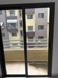 Séjour de l'appartement 4 pièces à louer à Attécoubé, Cité ADDOHA avec baie vitrée coulissante ouvrant sur le balcon