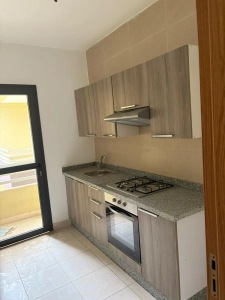 Cuisine équipée de l'appartement 4 pièces à louer à Attécoubé, Cité ADDOHA avec placards en bois et hotte