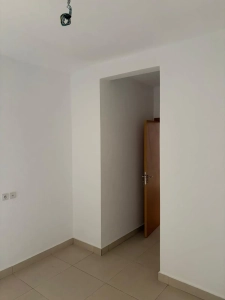 Pièce de vie de l'appartement 4 pièces à louer à Attécoubé, Cité ADDOHA avec alcôve et murs blancs