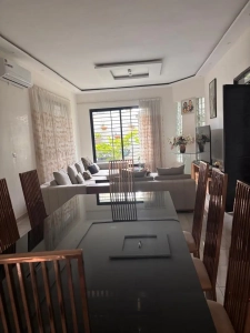 Salle à manger de la villa à louer à Bingerville, grande table et chaises en bois