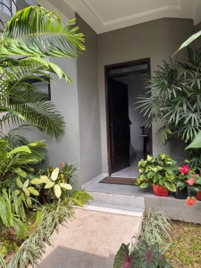 Entrée de la villa à louer à Bingerville avec jardin de palmiers et de plantes fleuries