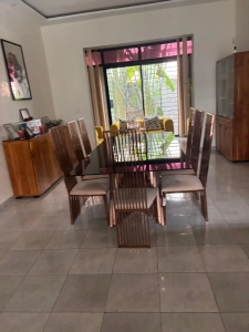Salle à manger de la villa à louer à Bingerville avec table en bois, six chaises et buffet