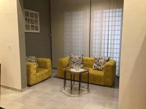 Petit salon avec deux fauteuils jaunes dans la villa à louer à Bingerville