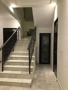 Escalier intérieur avec rampe en fer forgé dans la villa à louer à Bingerville