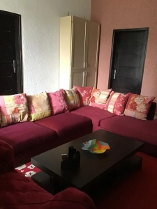 Coin salon avec canapé d'angle et table basse dans la villa à louer à Bingerville