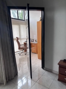 Bureau lumineux avec fauteuil et grande porte vitrée dans la villa à louer à Bingerville